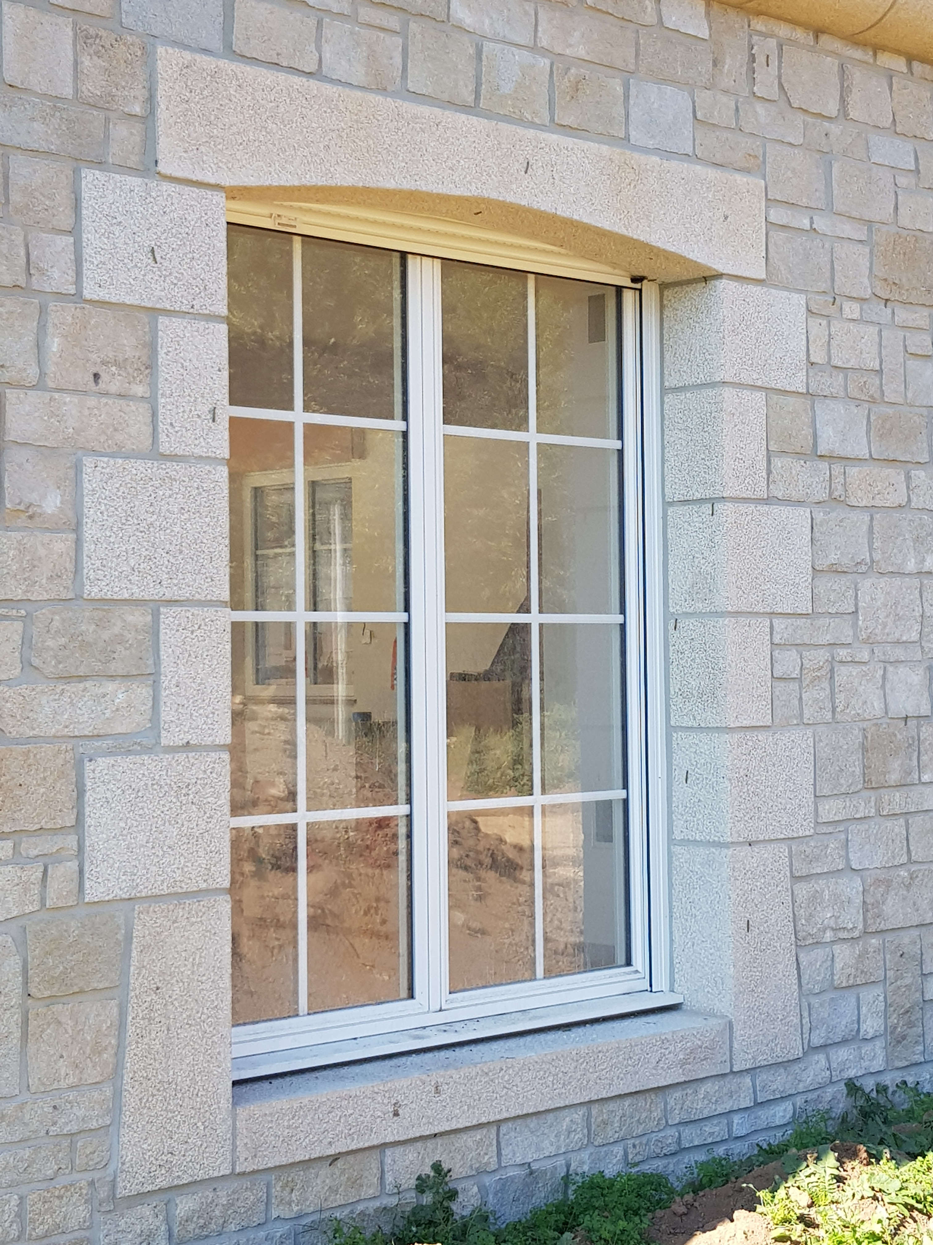 Ouverture en granit beige, finition bouchardée