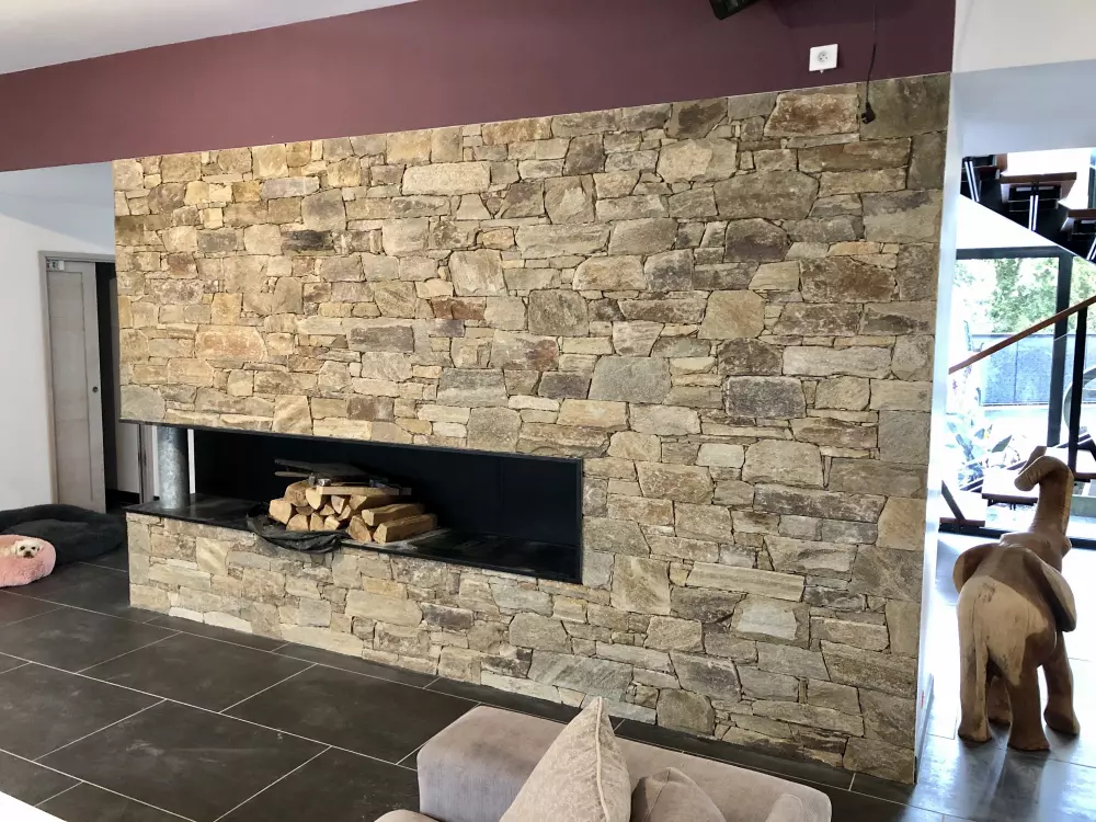 Habillage en parement à coller en gneiss sur cheminée intérieur