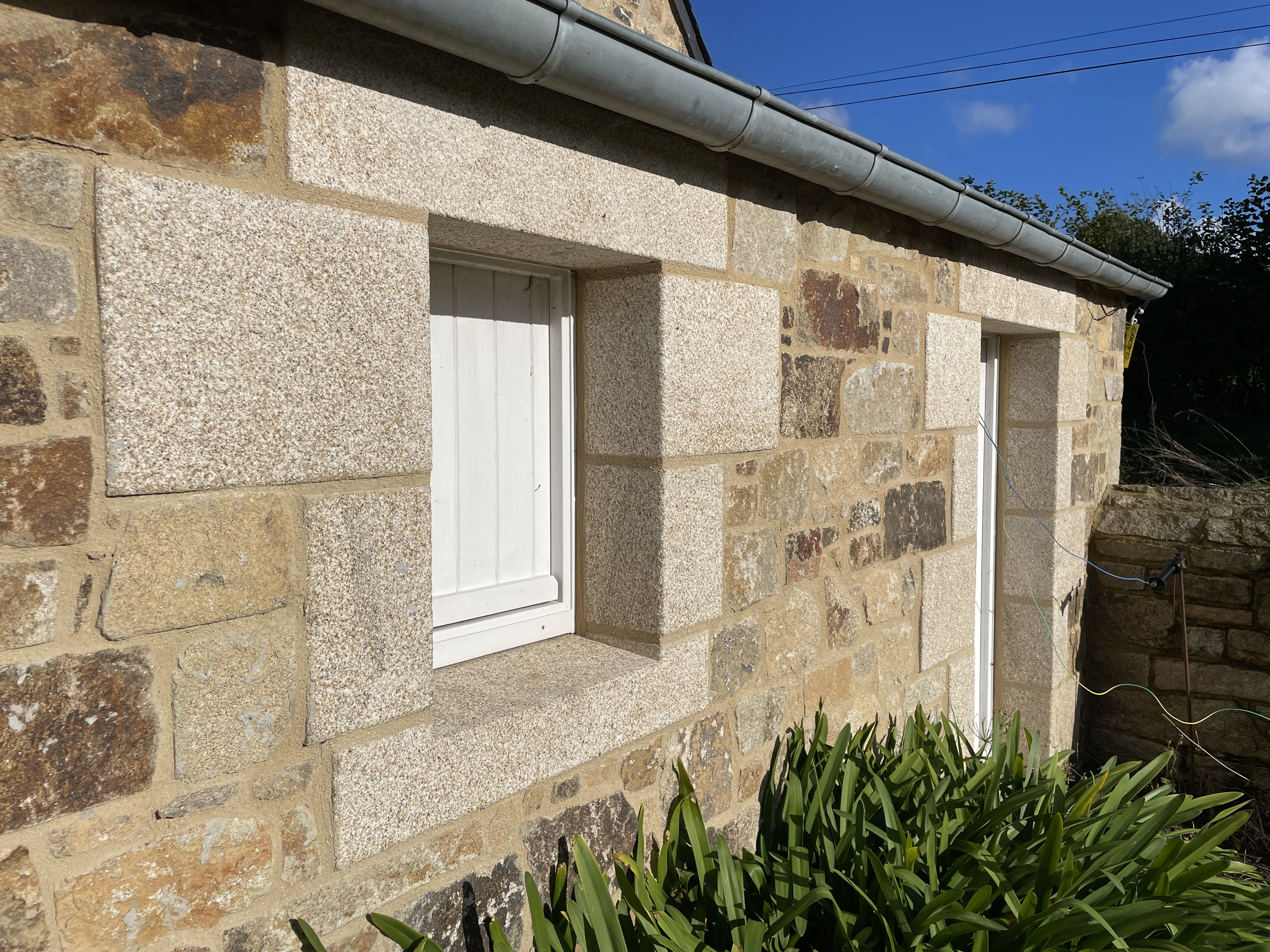 Encadrement évidé en granit beige bouchardé