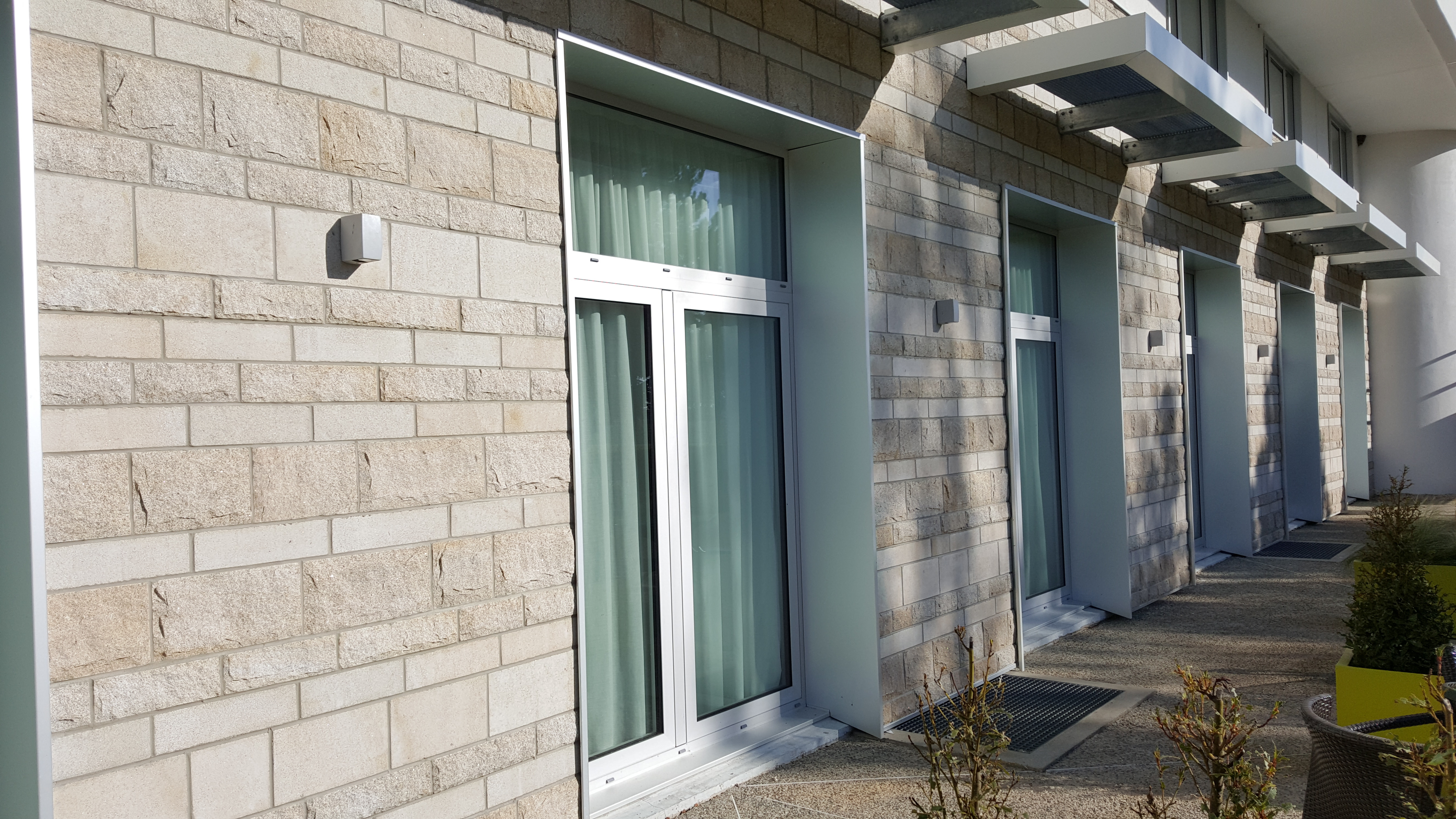 Mélange de pierre à coller sablée et éclatée, pose au rang